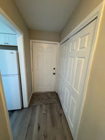a view of a hallway with wooden floor and staircase