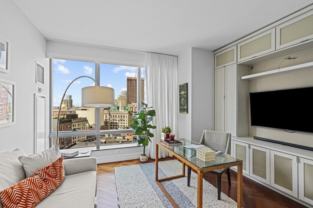 1 Avery Street, Unit U19D Boston, MA 02111 - Photo 15 of 27 a living room with furniture and a flat screen tv