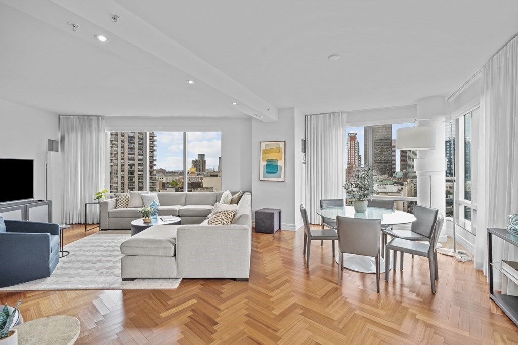 1 Avery Street, Unit U19D Boston, MA 02111 - Photo 2 of 27 a living room with furniture and a flat screen tv