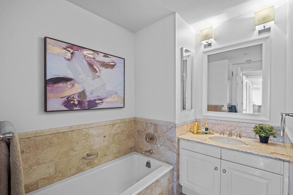 1 Avery Street, Unit U19D Boston, MA 02111 - Photo 21 of 27 a bathroom with a tub a sink and mirror