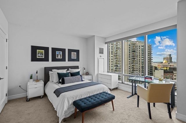 a bedroom with furniture and a large window
