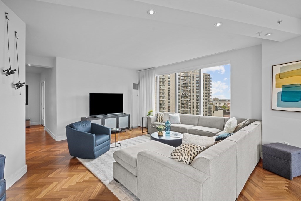 1 Avery Street, Unit U19D Boston, MA 02111 - Photo 3 of 27 a living room with furniture and a flat screen tv