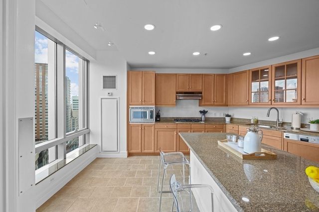 a large kitchen with stainless steel appliances granite countertop a stove a sink and a refrigerator