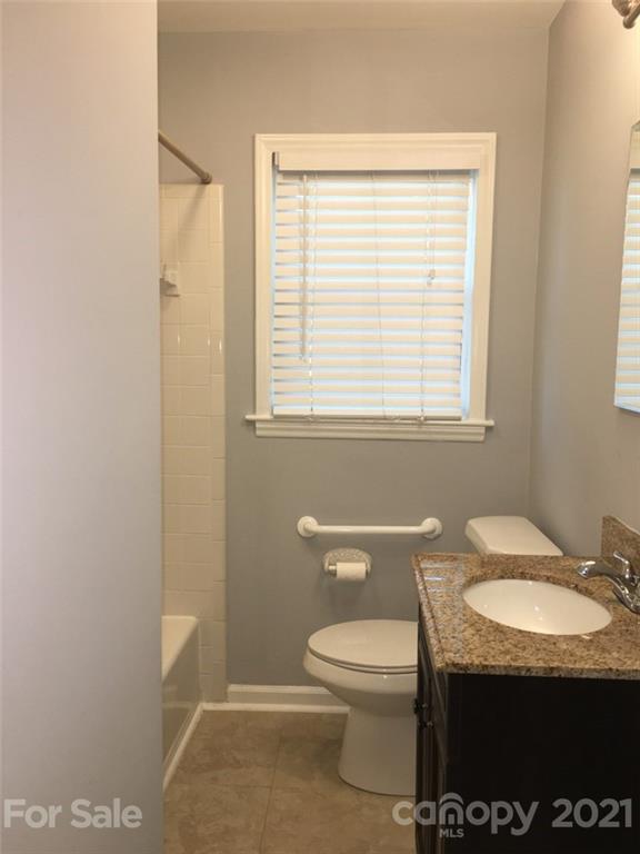3633 Kempton Place Charlotte, NC 28208 - Photo 22 of 32 a bathroom with a granite countertop toilet and a sink