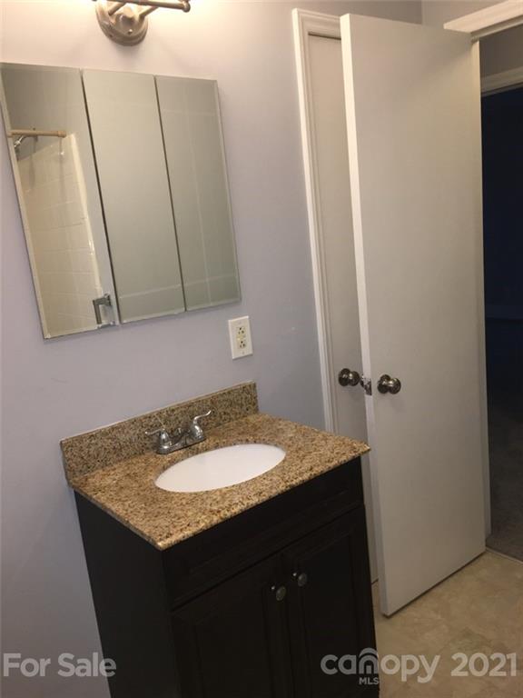 3633 Kempton Place Charlotte, NC 28208 - Photo 24 of 32 a bathroom with a granite countertop sink and a mirror