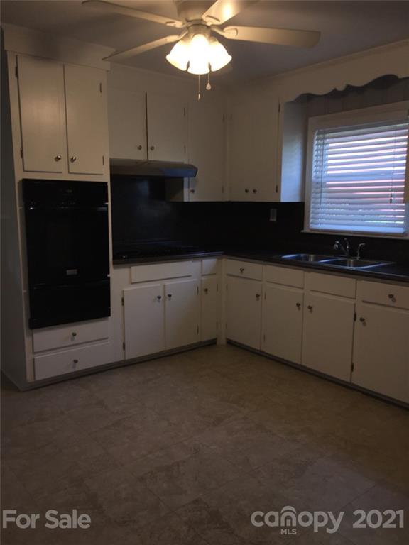 3633 Kempton Place Charlotte, NC 28208 - Photo 26 of 32 a kitchen with stainless steel appliances a stove microwave and cabinets