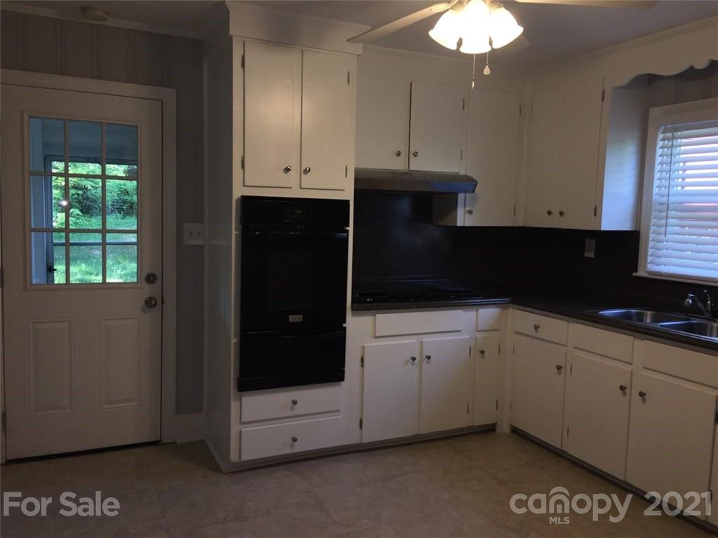 3633 Kempton Place Charlotte, NC 28208 - Photo 27 of 32 a kitchen with stainless steel appliances white cabinets and a sink