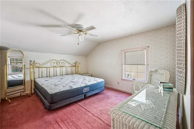 a bedroom with a bed a chandelier and dresser