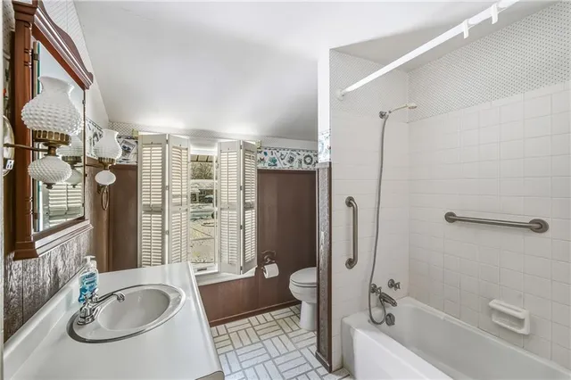 a bathroom with a tub sink and mirror