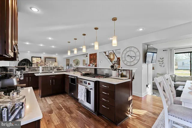 a kitchen with stainless steel appliances granite countertop a sink a stove and a refrigerator