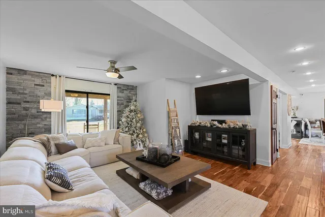 a living room with furniture a dining table and a floor to ceiling window