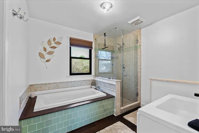 a bathroom with a tub sink and mirror