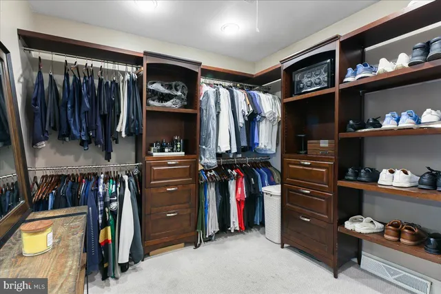 a view of staircase with lots of frames on wall and wooden floor