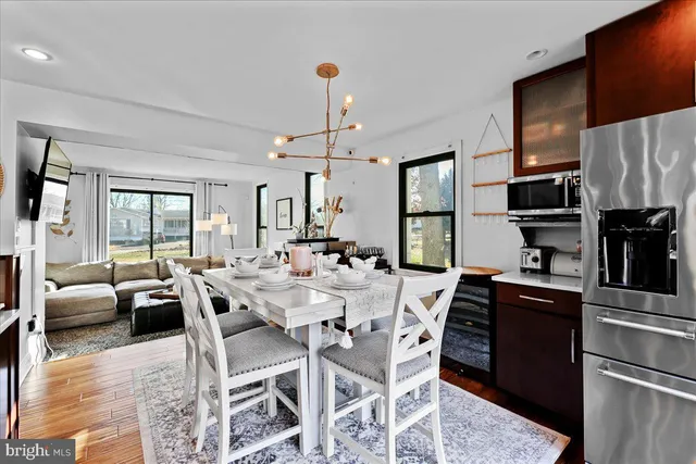 a large kitchen with stainless steel appliances granite countertop a stove a sink dishwasher and white cabinets with wooden floor