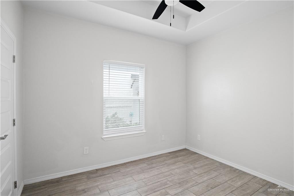 1511 Playa Drive, Unit 2 Weslaco, TX 78596 - Photo 17 of 28 an empty room with ceiling fan and windows