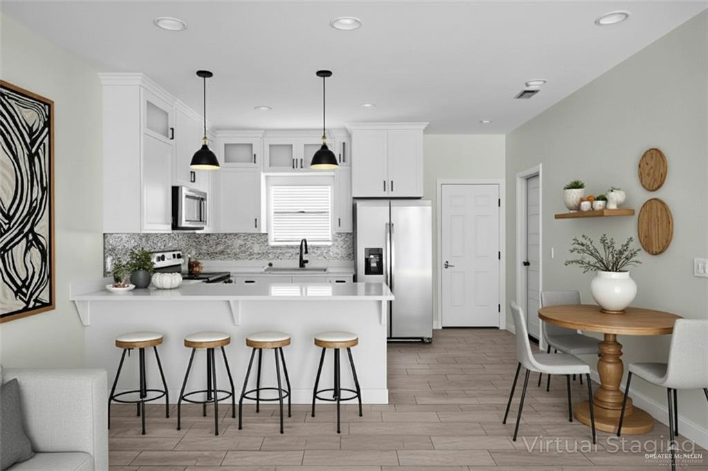 1511 Playa Drive, Unit 2 Weslaco, TX 78596 - Photo 6 of 28 a kitchen with stainless steel appliances granite countertop a table chairs stove and refrigerator
