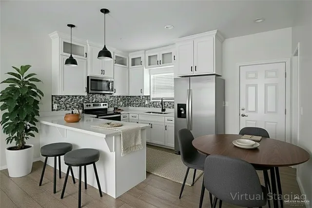 a kitchen with stainless steel appliances a table chairs and a refrigerator