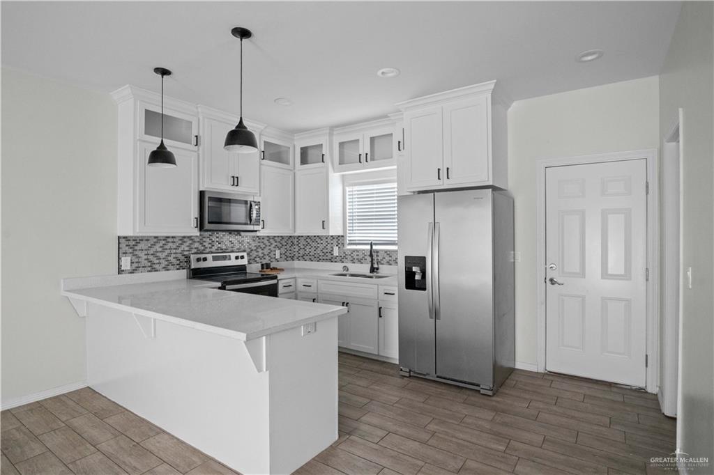 1511 Playa Drive, Unit 2 Weslaco, TX 78596 - Photo 9 of 28 a kitchen with stainless steel appliances a refrigerator sink and microwave