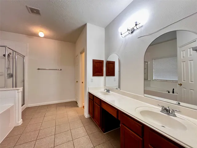 a spacious bathroom with a double vanity sink a mirror and a shower