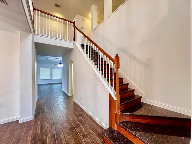 a view of staircase with wooden floor and a rug
