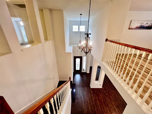a view of a hallway with wooden floor and staircase