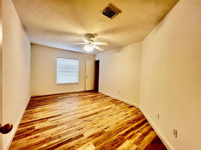 a view of a big room with wooden floor and fan in a room