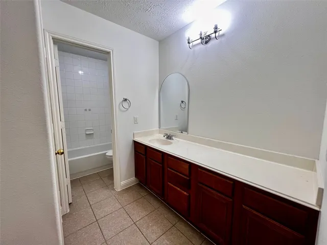 a spacious bathroom with a bathtub sink and mirror