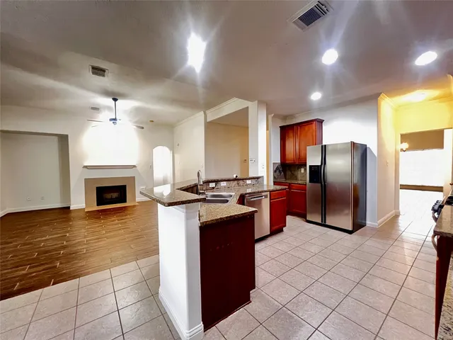 a kitchen with stainless steel appliances granite countertop a refrigerator a stove a sink and a microwave