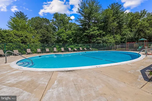 a view of a swimming pool and trees in the background