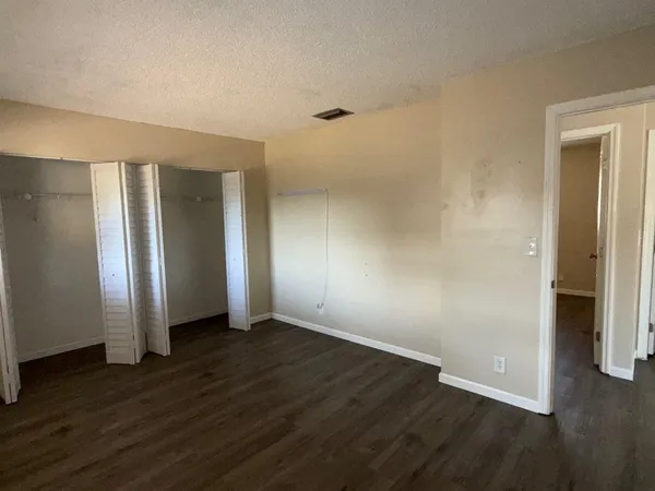 an empty room with wooden floor and closet