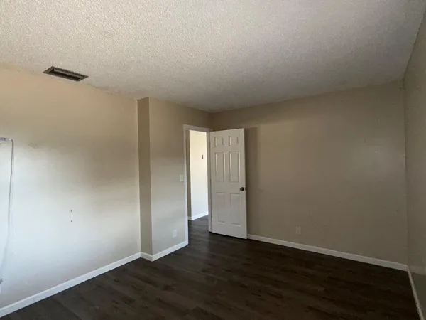 a view of an empty room with wooden floor