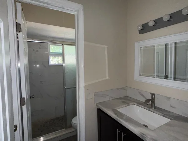 a bathroom with a granite countertop sink and a mirror