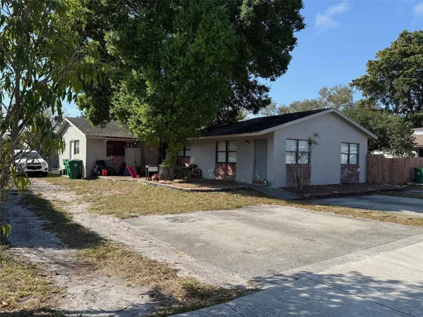 a view of a house with a yard and large tree