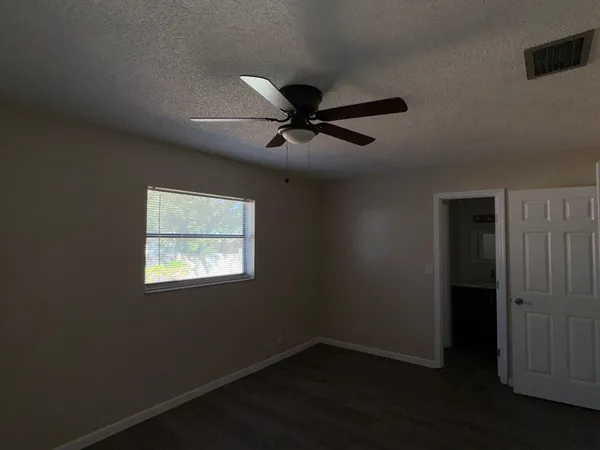 a view of an empty room with a ceiling fan and a window