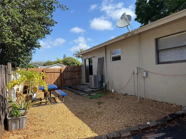 a backyard of a house with table and chairs