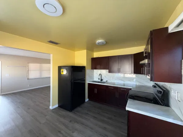 a kitchen with stainless steel appliances granite countertop a sink and a refrigerator