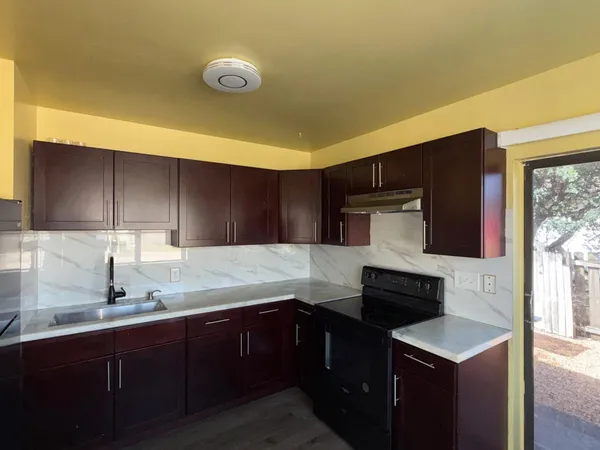 a kitchen with granite countertop a sink and a stove
