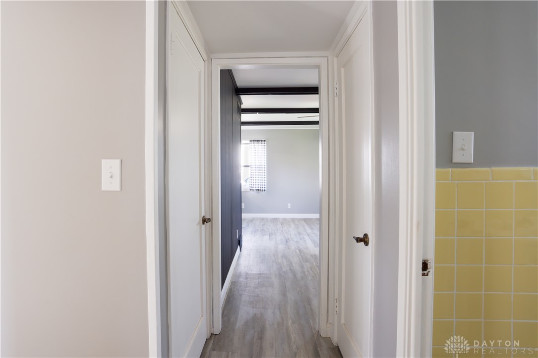 1627 Joselin Road Dayton, OH 45432 - Photo 19 of 28 This interior hallway leads to the living room featuring beamed ceilings and vinyl plank flooring.