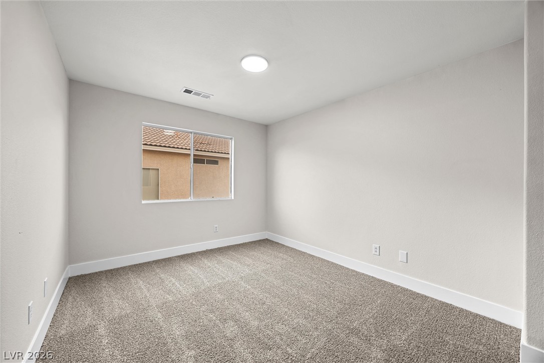 2650 Whisper Ridge Street Las Vegas, NV 89156 - Photo 22 of 28 Soft carpeting pairs with neutral walls and a wide window in this comfortable bedroom.