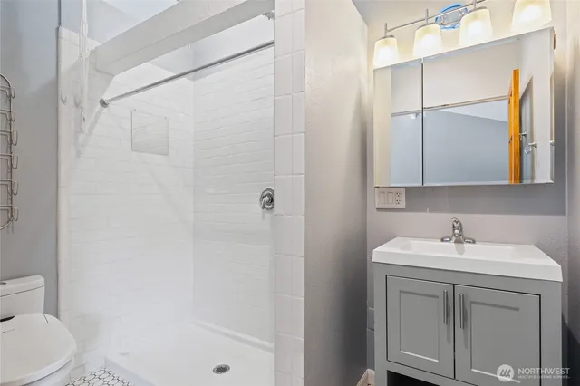 a bathroom with a sink a toilet and shower