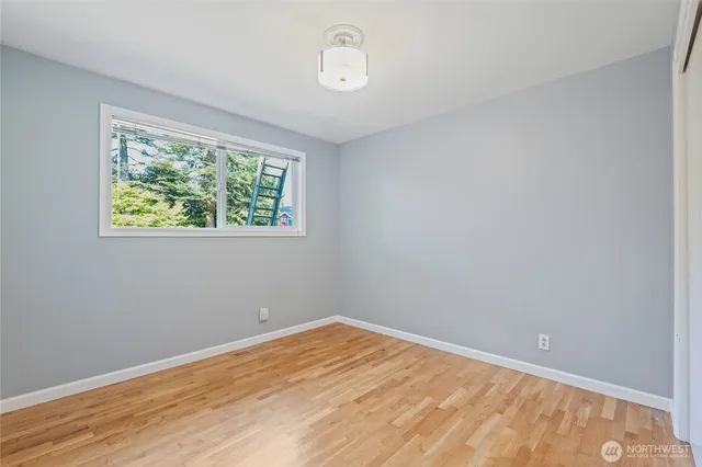 a view of a room with wooden floor and window