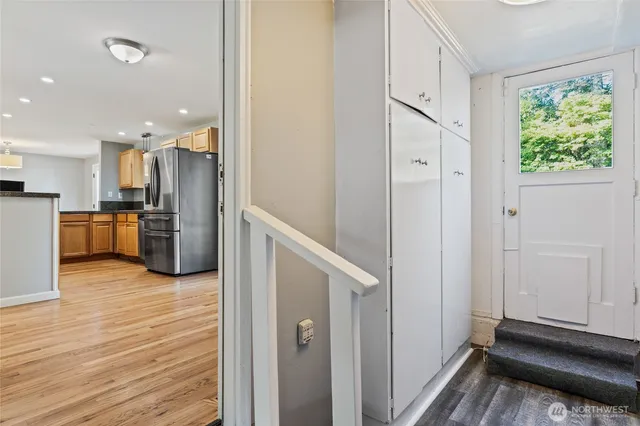 a view of a kitchen with wooden floor and a refrigerator