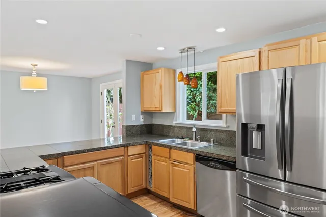 a kitchen with stainless steel appliances granite countertop a refrigerator and a sink