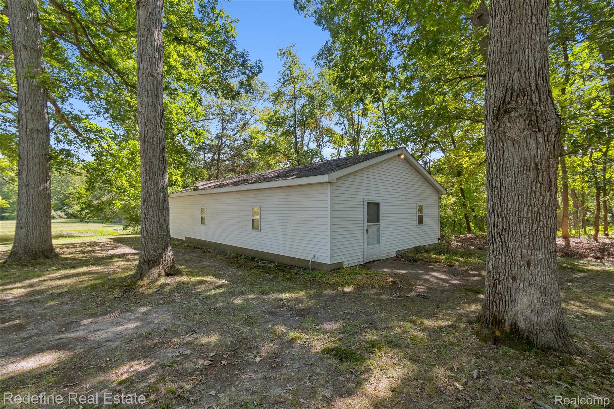 3777 Dorr Road Brighton, MI 48116 - Photo 6 of 77 Back of house featuring view of wooded area
