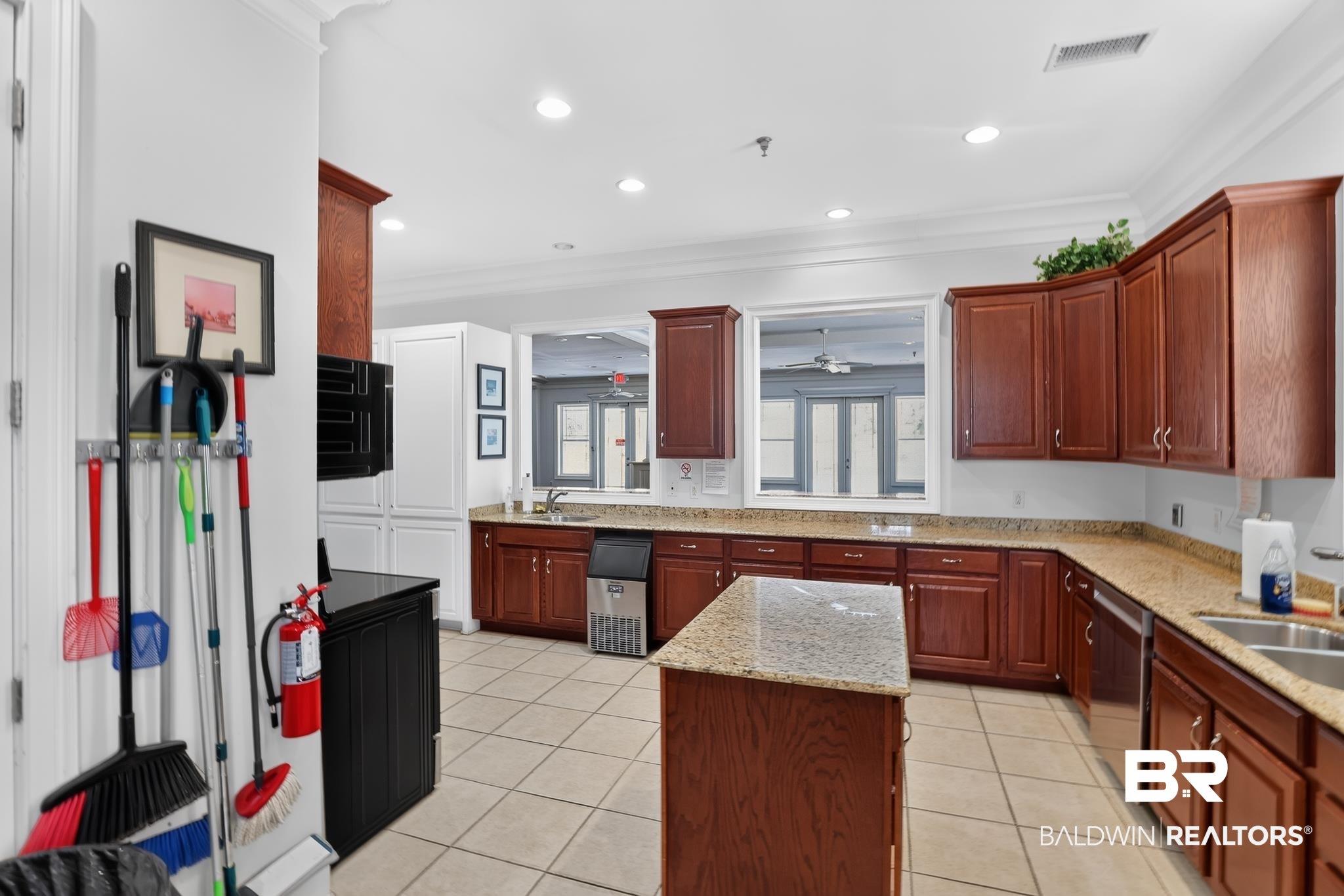 1210 Primrose Lane Foley, AL 36535 - Photo 28 of 33 Spacious kitchen featuring warm wood cabinetry, granite-style countertops, and a central island