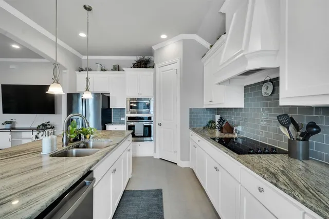 a kitchen with stainless steel appliances granite countertop a stove a refrigerator a oven a sink a table and chairs