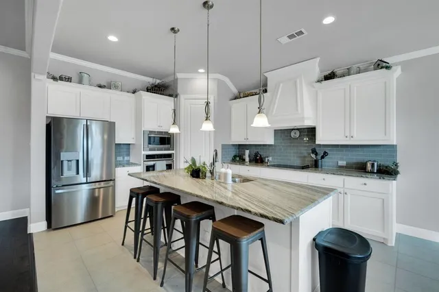 a kitchen with stainless steel appliances kitchen island granite countertop a sink and cabinets