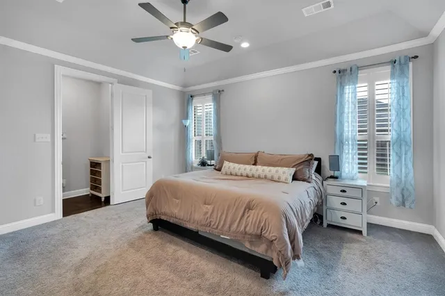 a bedroom with a bed and a ceiling fan