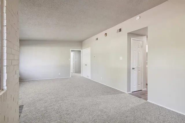 en empty room with a ceiling fan and a chandelier fan