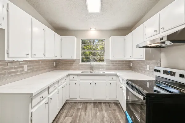 a kitchen with stainless steel appliances a sink stove and refrigerator